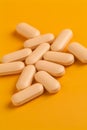 Orange vitamin pills on an orange background Royalty Free Stock Photo