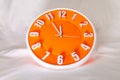 Orange Wall Clock on white blur background. Royalty Free Stock Photo