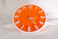 Orange Wall Clock on white blur background. Royalty Free Stock Photo