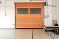 Orange warehouse shutter door close next to loading pallets interior point of view Royalty Free Stock Photo