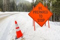 Orange Warning Sign on a Snowy Road