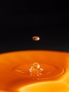 Orange water drop with black background Royalty Free Stock Photo