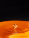 Orange water drop with black background Royalty Free Stock Photo