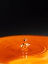 Orange water drop with black background Royalty Free Stock Photo