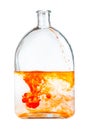 Orange watercolour paint dissolves in glass flask