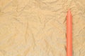 orange wax crayon on a recycled crumpled paper surface Royalty Free Stock Photo