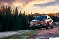 Orange 4wd suv parked in mountain at sunrise
