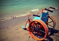 orange wheel chair on the beach with old toned effect Royalty Free Stock Photo