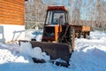 Wheeled snow plow tractor with blade in winter Royalty Free Stock Photo