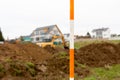 orange and white boning rod for surveying in the foreground of a construction site in a new development area Royalty Free Stock Photo