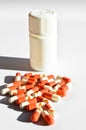 Orange and white capsule pills and white medicine box, isolated on white background Royalty Free Stock Photo