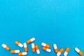 Orange white capsules pills on a blue background. Medical background, template.