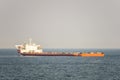 Orange and white colour project cargo ship anchors in the open sea