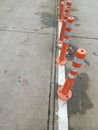 Orange white flexible plastic bollards in middle of road