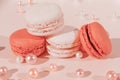 Orange and white macarons on light wooden background with beautiful pearls decoration. French Pastel Macaroons. Blurred focus