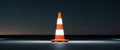 An orange and white road safety cone at night time. Royalty Free Stock Photo