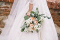 bride with wedding bouquet from orange and wite roses