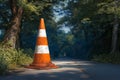 Orange and white street cone stands in forest background, cautionary Royalty Free Stock Photo