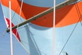 An orange and white stripey sail on the end of a pole