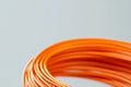 Orange wire coil twisted neatly for crafting projects or electrical use in a workspace Royalty Free Stock Photo