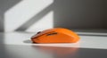 Orange Wireless Computer Mouse on White Desk in Bright Light Royalty Free Stock Photo