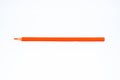 Orange wood pencil crayon with a sharp tip  on a white background Royalty Free Stock Photo
