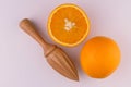 Orange and wooden juicer on a white background. Flat lay. Royalty Free Stock Photo