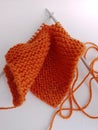 Orange wool knitting and needles on a white background Royalty Free Stock Photo