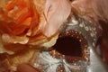 Orange work detail of handcrafted mask of the Venice carnival with bright feathers and pink flowers