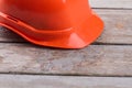 Orange worker`s helmet on the old wooden table. Royalty Free Stock Photo
