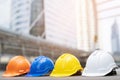 Orange, yellow, blue, white hard safety wear helmet hat in the project at construction Royalty Free Stock Photo