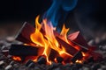 Glowing orange and yellow campfire burning on dark background with blue flames Royalty Free Stock Photo