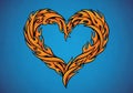 Orange and yellow flames intricately shaped into a heart against a blue background. The flames are Royalty Free Stock Photo