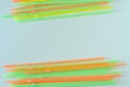 Orange, yellow and green drinking straws in frame