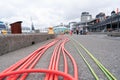 Orange and yellow and green polyethylene piping laid out along the waterfront ready for installation of services