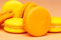 Orange and yellow macarons or macaroons stacked over pinky orange background Royalty Free Stock Photo