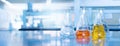 Orange yellow solution in science glass flask win blue chemistry laboratory banner background