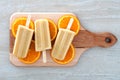 Orange yogurt popsicles on a wooden paddle board Royalty Free Stock Photo