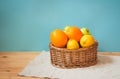 Oranges, apples and lemons in wicker basket on wooden table. Selective focus Royalty Free Stock Photo