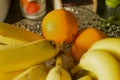 Oranges and bananas in a glass vase on the table Royalty Free Stock Photo