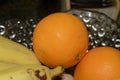 Oranges and bananas in a glass vase on the table Royalty Free Stock Photo