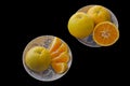 Oranges for breakfast. Healthy fruit in different plates on a black background