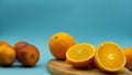 Oranges cut in half on a wooden board on a blue background with blood oranges on the right side of the image. Healthy food concept Royalty Free Stock Photo