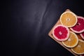 Oranges fruit on black wooden boards. Halves of juicy orange on black background. Orange fruit, citrus minimal concept. Top view, Royalty Free Stock Photo