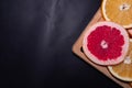 Oranges fruit on black wooden boards. Halves of juicy orange on black background. Orange fruit, citrus minimal concept. Top view, Royalty Free Stock Photo