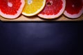 Oranges fruit on black wooden boards. Halves of juicy orange on black background. Orange fruit, citrus minimal concept. Top view, Royalty Free Stock Photo