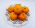 Oranges group on a plate, white background