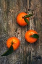 Oranges, mandarins, clementines, citrus fruits with leaves on wooden background