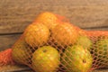 Oranges in a mesh on wood Royalty Free Stock Photo