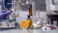 Oranges, mushrooms and nuts on a laboratory table with vitamin names. The hand of the laboratory assistant holds test